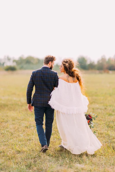 Noiva feliz e noivo andando no campo no campo — Fotografia de Stock