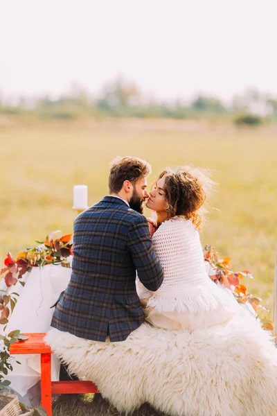Esküvői pár megcsókolja a táj piros ág — Stock Fotó