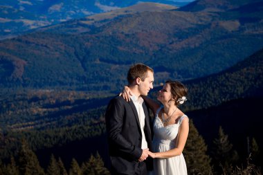 Bride and groom happily smiling. Amazing mountains view on background