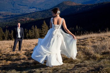 Muhteşem gelin sahada dans ediyor. Harika dağ manzara arka plan