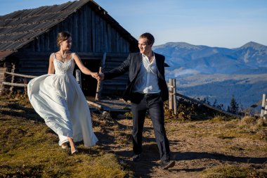 Beautiful newlyweds walking on the mountain countryside. Honeymoon