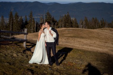 Düğün çifti öpüşüyor. arka planda güzel dağlar