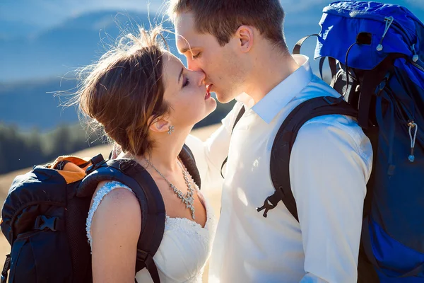 Affascinante coppia di sposi turistici baciare sulla vetta della montagna da vicino — Foto Stock