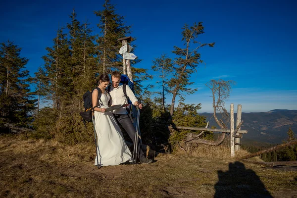 Wedding tourist couple look into the map. Honeymoon in mountains