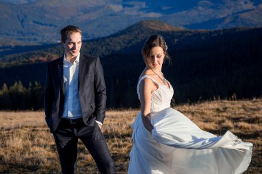 Beatiful düğün çift dağın tepesinde poz. Güneşli bir gün