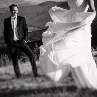 Wedding couple posing on the top of mountain. Black and white photo