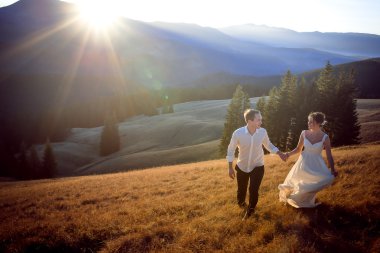 Güzel düğün çift çalıştıran ve sahip eğlenceli dağlarla çevrili alan üzerinde