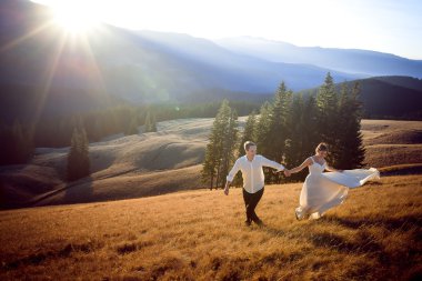 Güzel düğün çift çalıştıran ve sahip eğlenceli dağlarla çevrili alan üzerinde