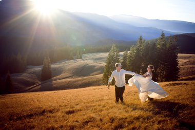 Güzel düğün çift çalıştıran ve sahip eğlenceli dağlarla çevrili alan üzerinde