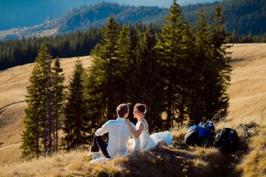 Romantik düğün çift dağ zirvesinde oturuyor. Alpler'de Balayı