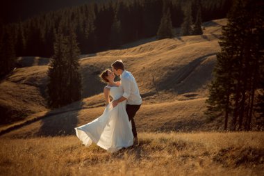 Güzel düğün çift usulca sarılma. Arka plan üzerinde güzel dağ manzarası