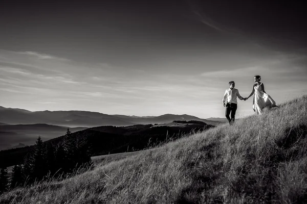 Couple de mariage romantique marchant dans les montagnes. Photo noir et blanc — Photo