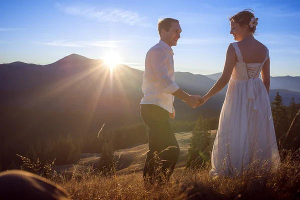 Wedding couple softly holding hands. Sunset in the mountains — ストック写真