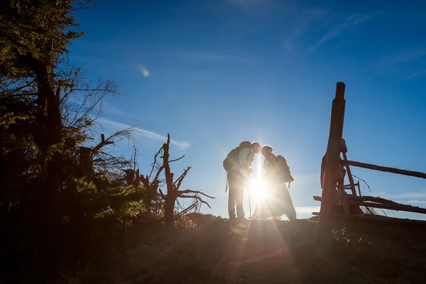 Schönes touristisches Hochzeitspaar küsst sich sanft gegen die Sonne auf alpiner Landschaft — Stockfoto