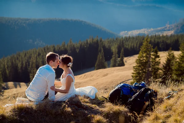 美しいロマンチックな花嫁と新郎は、山頂にキス。アルプスのハネムーン — ストック写真