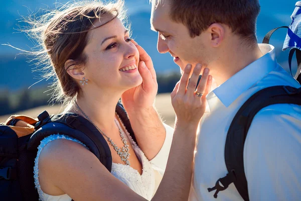 Felice turista sposa e sposo accarezzando faccia di ogni altro primo piano. Montagne sullo sfondo — Foto Stock