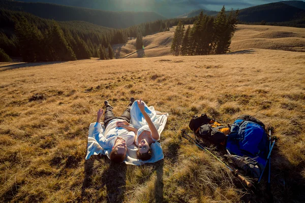 Romantische bruidspaar liggend op het gras in Bergen — Stockfoto