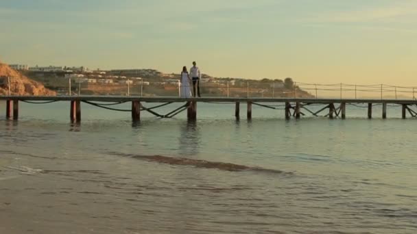 Pareja romántica de boda caminando en la playa en Egipto. Fondo de puesta de sol — Vídeo de stock