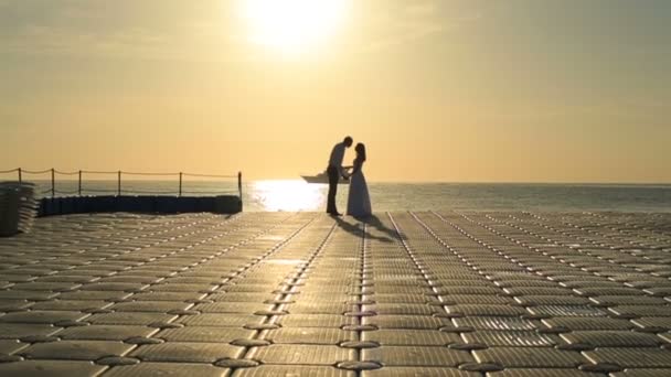 Silhouettes of romantic wedding couple kissing on yacht. Sunset backgound. Honeymoon in Egypt — Stock Video