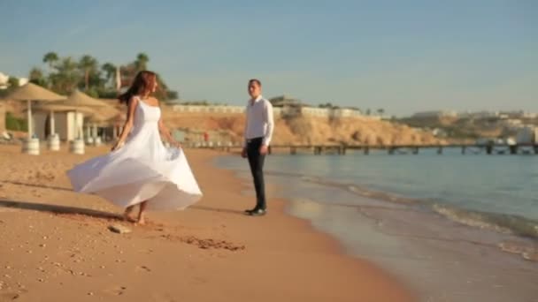 Ευτυχισμένη νύφη και τον γαμπρό τη διασκέδαση στην παραλία. Μήνας του μέλιτος — Αρχείο Βίντεο