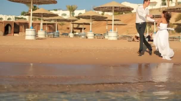 Feliz novia y novio riendo y divirtiéndose en la playa. Luna de miel — Vídeos de Stock