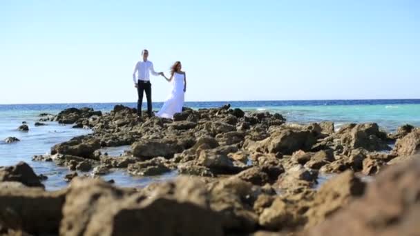 Mooie bruid en bruidegom poseren op de gestenigd oever in Egypte. Huwelijksreis — Stockvideo