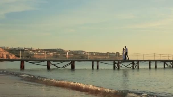 Romantikus esküvő házaspár gyaloglás-ra kikötő Egyiptomban. Naplemente, a háttérben — Stock videók