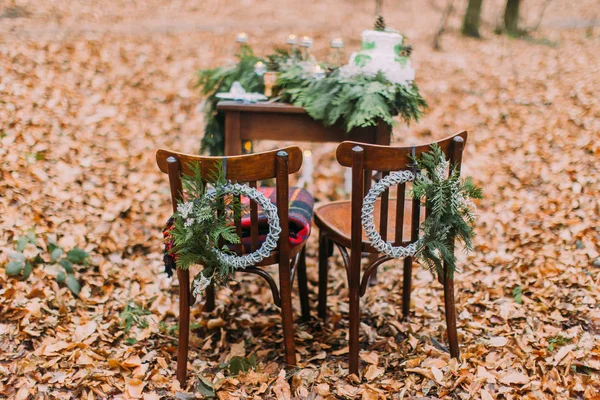 Mesa vintage com bolo e velas na floresta de outono. Cadeiras em primeiro plano — Fotografia de Stock