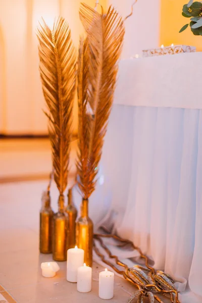 Kerzen und goldene Federn schließen sich an. Hochzeitsdekoration — Stockfoto