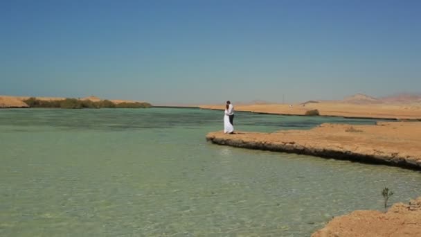 Glückliches Hochzeitspaar am Strand stehend. Flitterwochen in Ägypten — Stockvideo