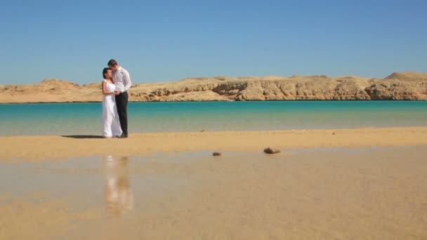 Pareja de bodas pasea por la playa en Egipto. Luna de miel exótica — Vídeo de stock