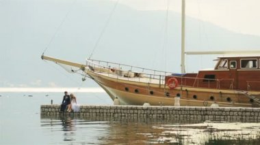 Yatak üzerinde oturan ve bacaklar Karadağ, Budva sallayarak mutlu evlilik çift