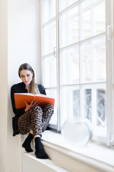 Krásná elegantní mladá dívka čtení knihy na parapet — Stock fotografie