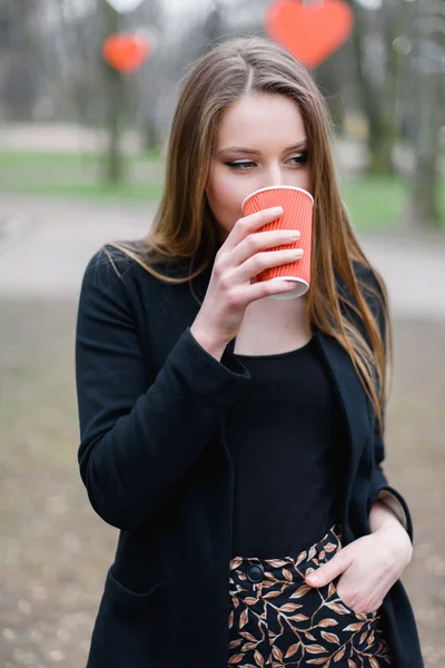 Портрет молодої красивої стильної дівчини, що п'є каву в парку — стокове фото