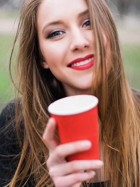 公園でコーヒーを飲みながら美しいスタイリッシュな少女の肖像画 — ストック写真