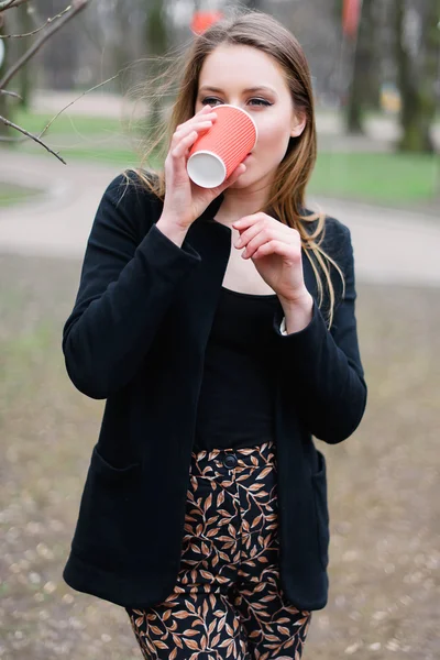 Retrato de menina bonita e elegante bebendo café no parque — Fotografia de Stock