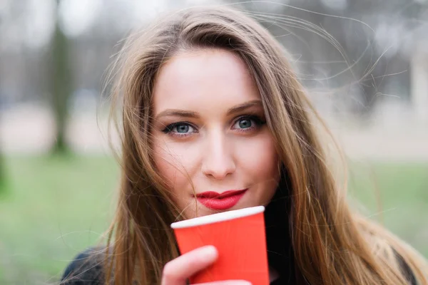 Portret van jonge mooi stijlvolle meisje, drinken koffie in het park — Stockfoto