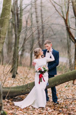 Sonbahar ormandaki güdük oturan güzel genç Düğün çifti