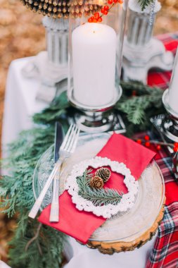 Güzel bir şekilde dekore edilmiş Noel masa mumlar ve çam ağaçları ile yakından