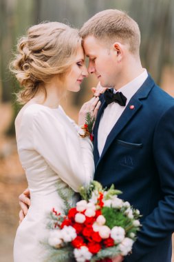 Yakışıklı damat ve güzel gelin sevgiyle sonbahar ormanda bakıyoruz