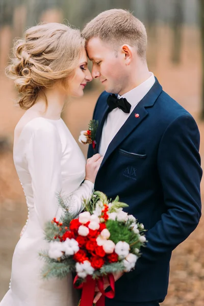 Yakışıklı damat ve güzel gelin sevgiyle sonbahar ormanda bakıyoruz