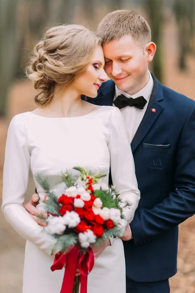 Handsome groom and beautiful bride lovingly look at each other in the autumn forest — Stock Photo, Image