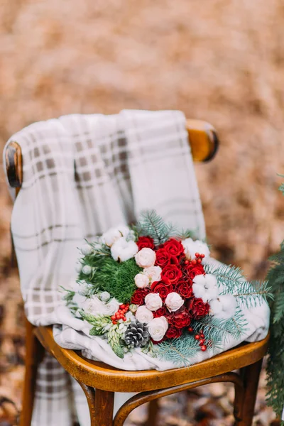 Vintage bouquqet of red roses and pine cones with ribbons on the chair. Forest background — Stock Photo, Image