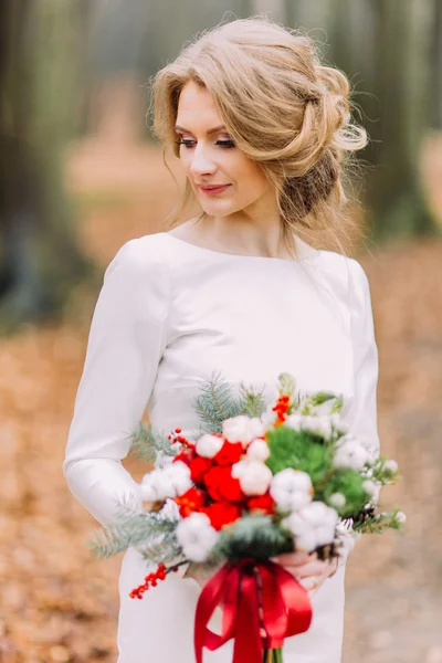 Attraktiv blond brud med bukett av röda och vita rosorna i höst park — Stockfoto