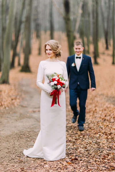 Feliz elegante jovem noiva e noivo andando na floresta de outono — Fotografia de Stock