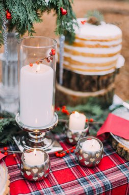 Güzel bir şekilde dekore edilmiş Noel masa kek, mumlar ve çam ağaçları ile yakından