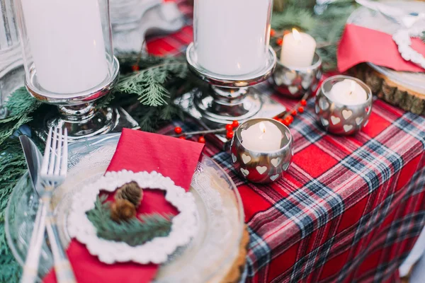 Beautiful decorated christmas table with candles and pines close up — Stock Photo, Image