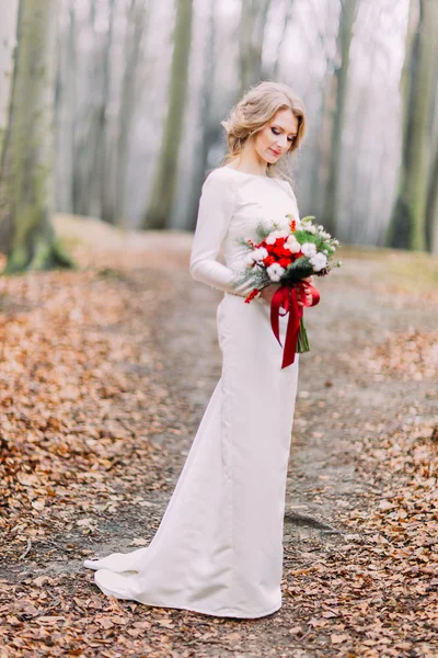 Fullängds porträtt av vackra blonda bruden på hösten skogen med bröllop bukett — Stockfoto