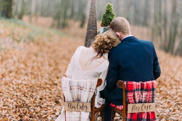 Casamento casal sentado e abraçando na mesa de férias na floresta de outono — Fotografia de Stock