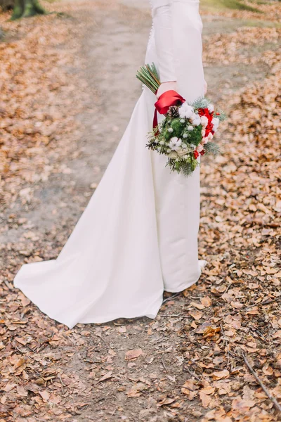 Beautiful bride in long lace dress holding bouquet with at the autumn forest. Half-length, no face — Stock Photo, Image